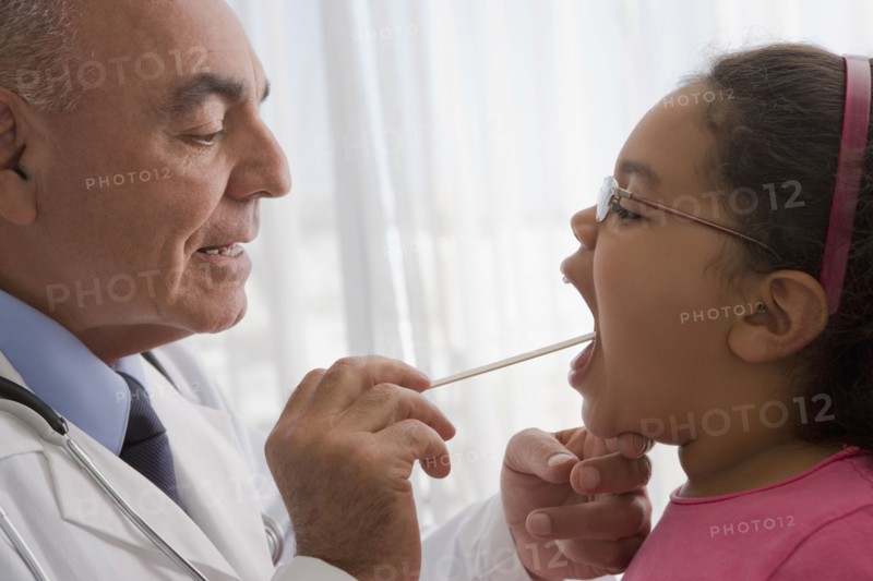 Hispanic doctor checking patient's throat