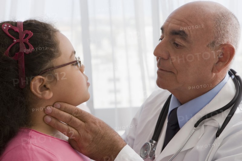 Hispanic doctor checking patient's throat