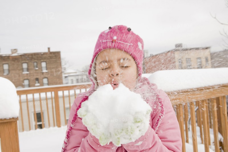Hispanic girl playing with snowball