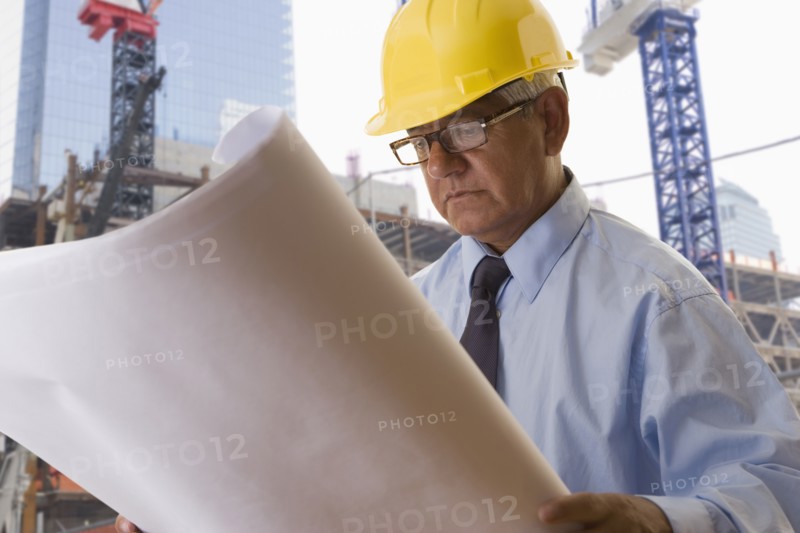 Hispanic businessman reading blueprints