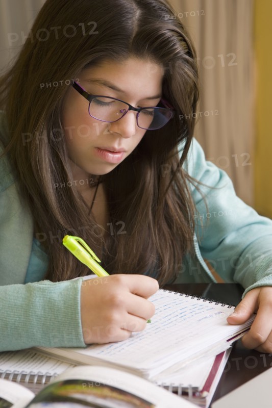 Hispanic girl doing homework at table