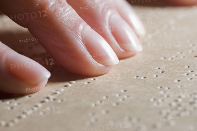 Close up of Hispanic woman reading Braille