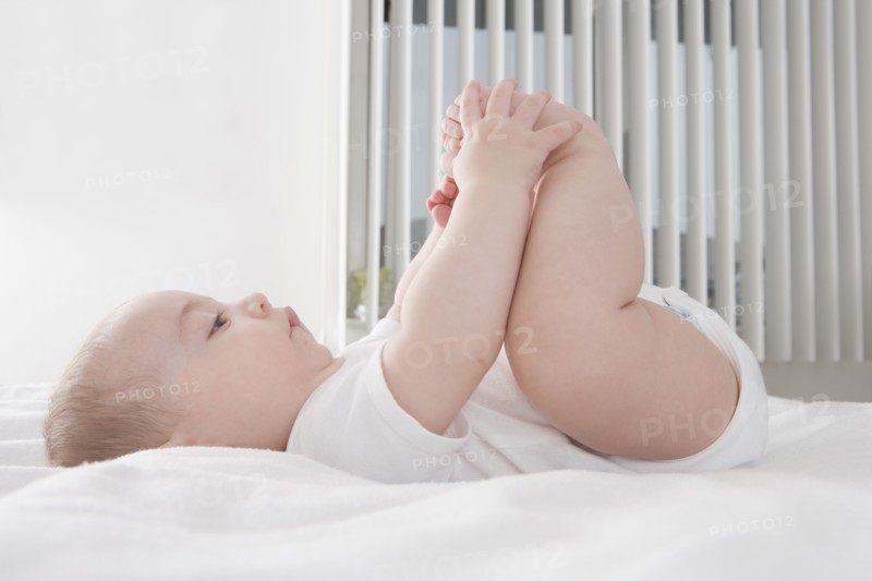 Hispanic baby boy playing with feet