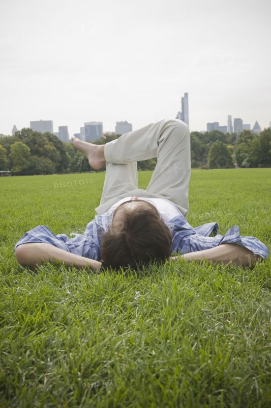 Hispanic man laying in grass at park