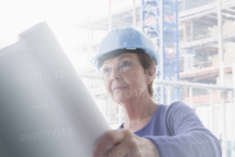 Hispanic architect reading blueprints