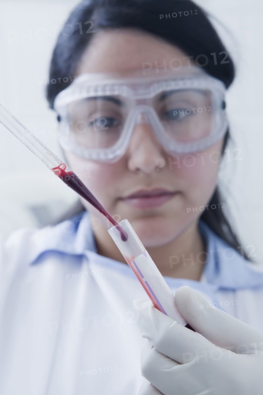 Hispanic scientist pipetting blood sample