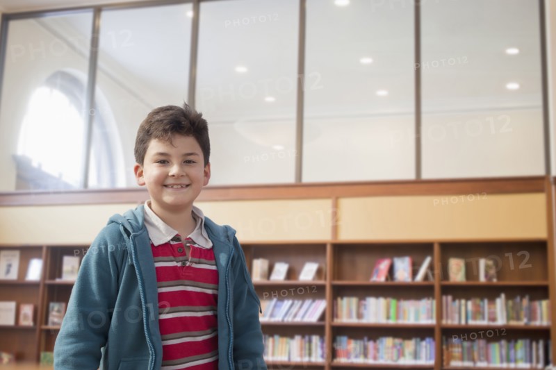 Hispanic boy smiling in library