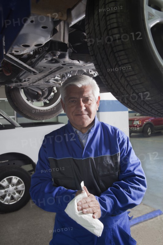 Older Hispanic mechanic working in garage