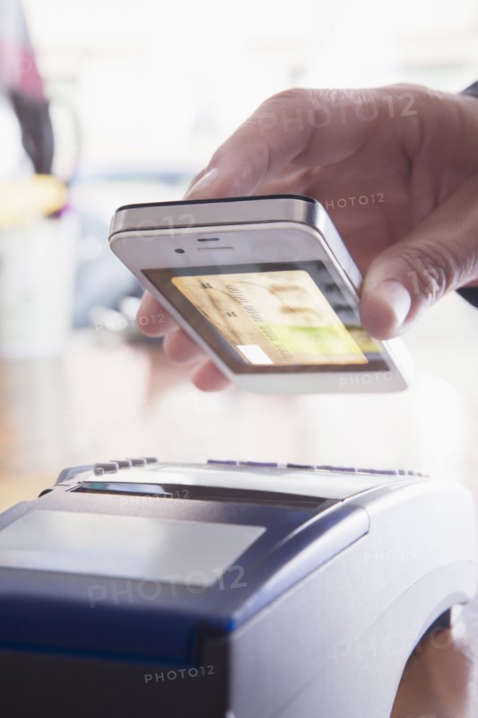 Hispanic woman scanning credit card from cell phone