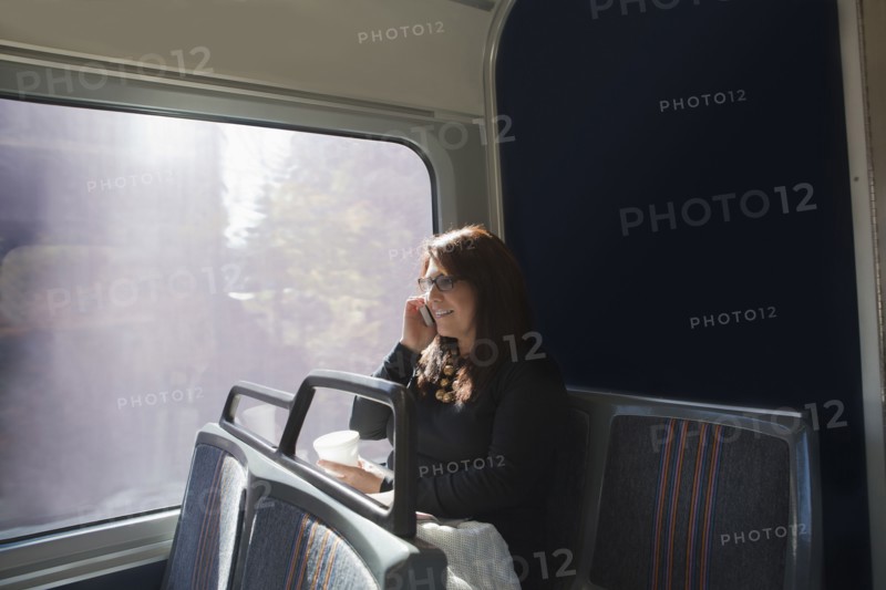 Hispanic woman talking on cell phone on train