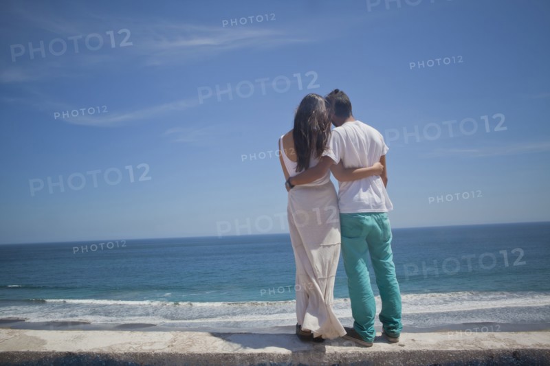 Hispanic couple admiring seascape at beach
