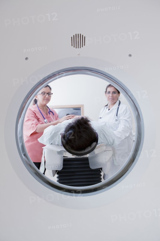 Hispanic doctor and nurse comforting patient at scanner