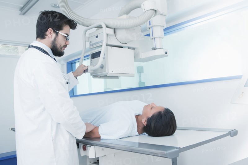 Hispanic doctor comforting patient at x-ray machine