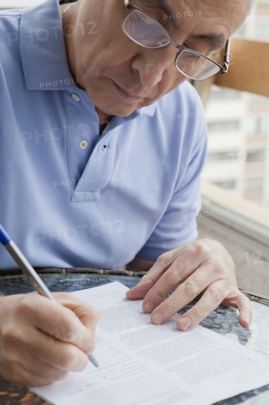 Hispanic man writing on paperwork