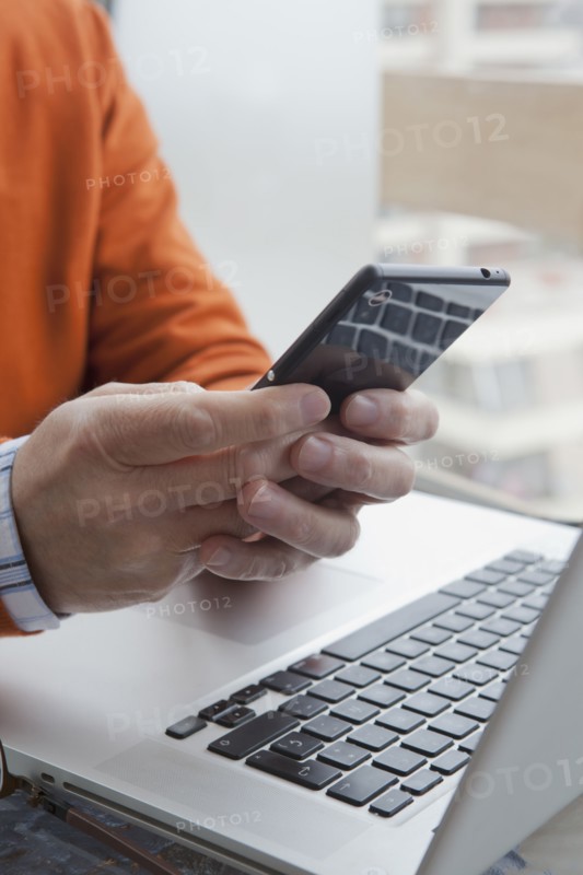 Hands of Hispanic man texting on cell phone