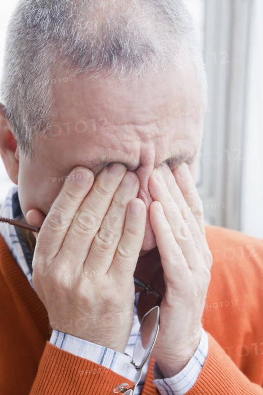 Hispanic man rubbing eyes