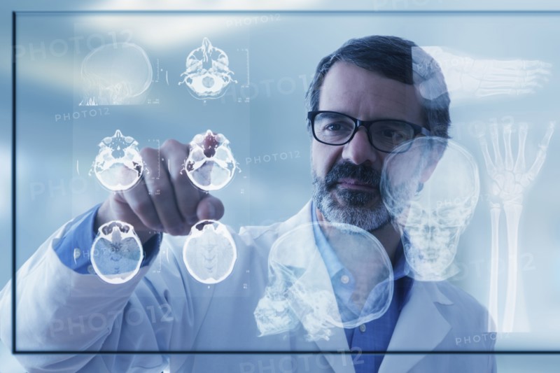 Hispanic doctor examining x-rays on virtual screen