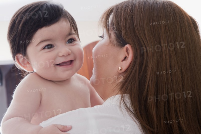Hispanic mother carrying baby boy