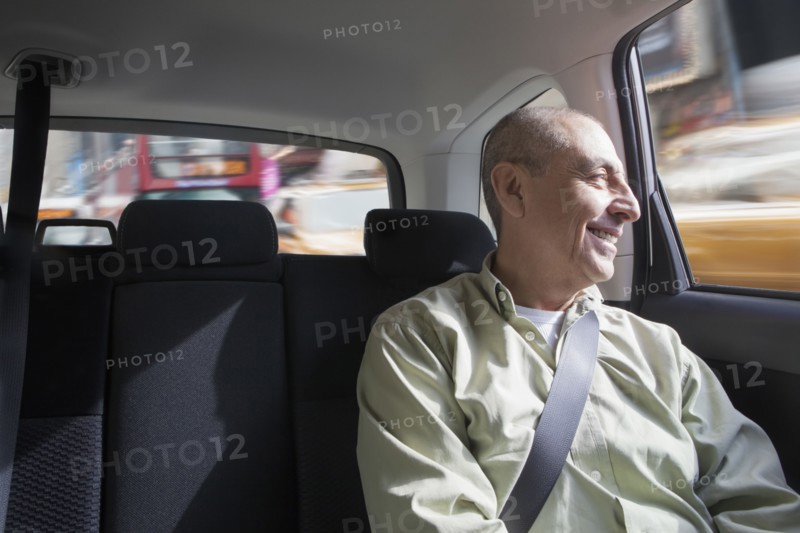 Smiling Hispanic man riding in car