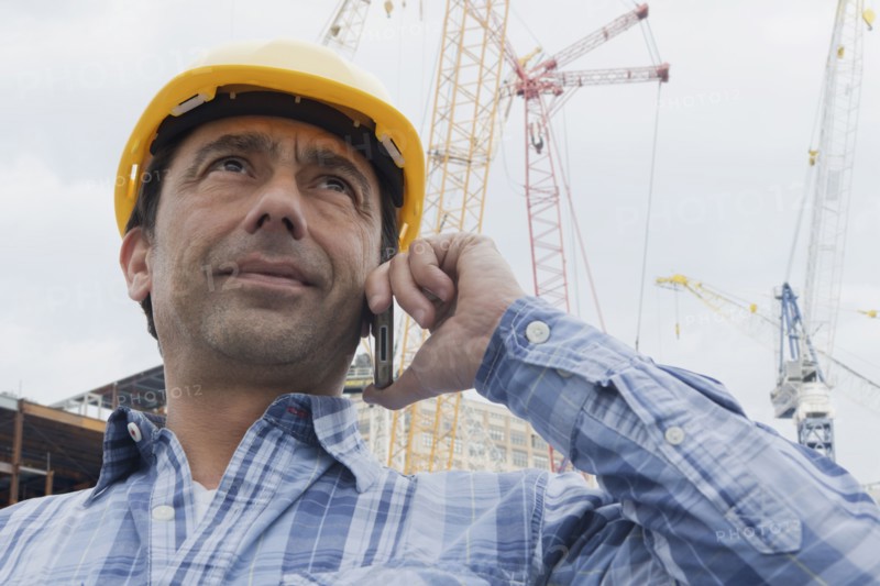 Hispanic construction worker talking on cell phone