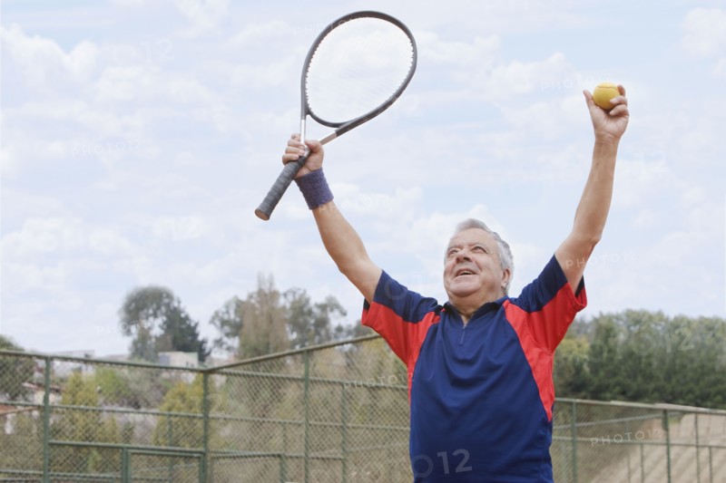 Excited senior Hispanic man playing tennis