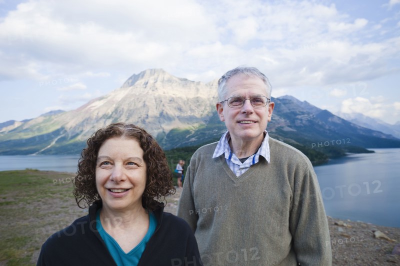 Caucasian couple standing outdoors with mountain in background