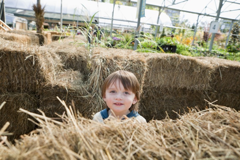Caucasian boy standing near hay bales