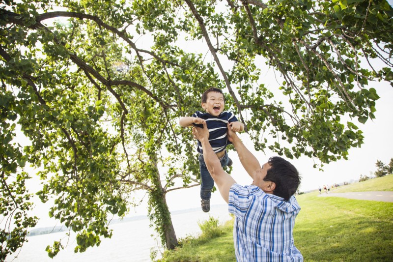 Japanese father playing with son in park