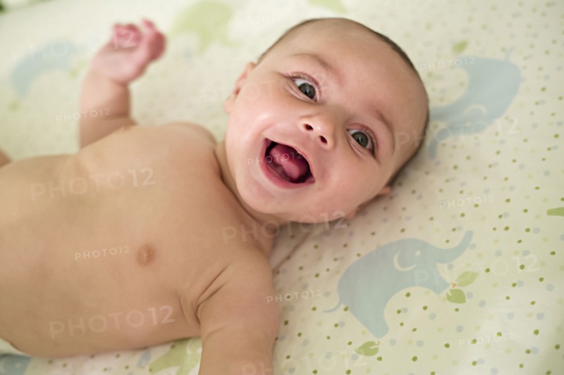 Smiling baby laying on blanket