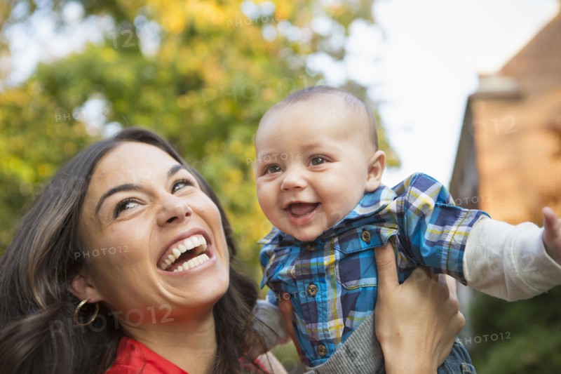 Smiling mother holding baby outdoors