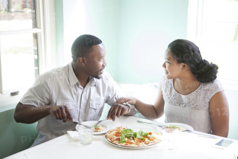 Smiling couple eating together at table