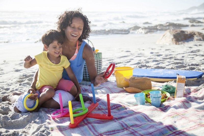 Mixed race mother and daughter playing at beach