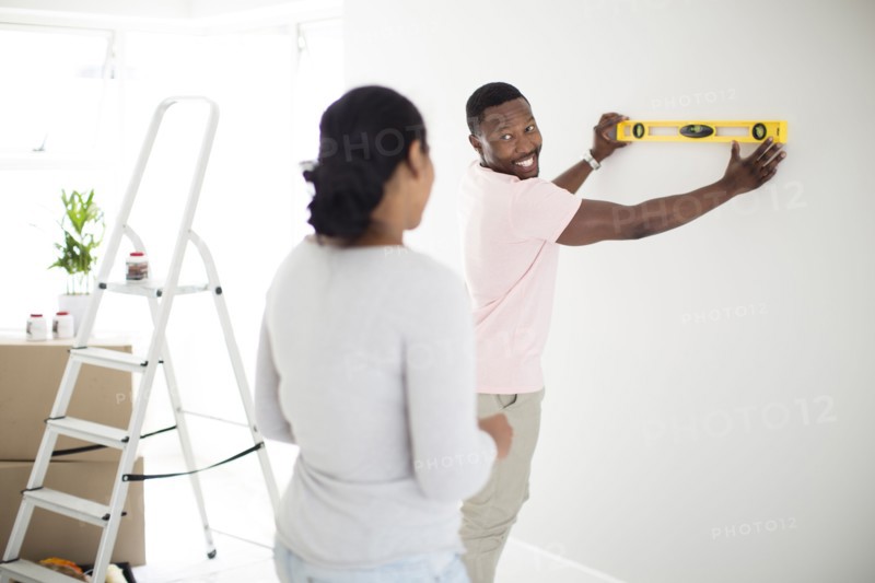 Couple using level in new home