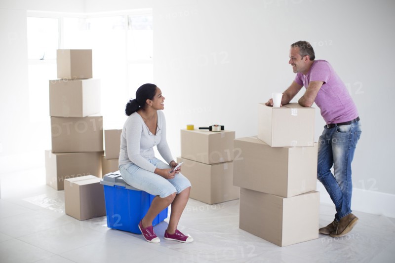 Couple with cardboard boxes in new home