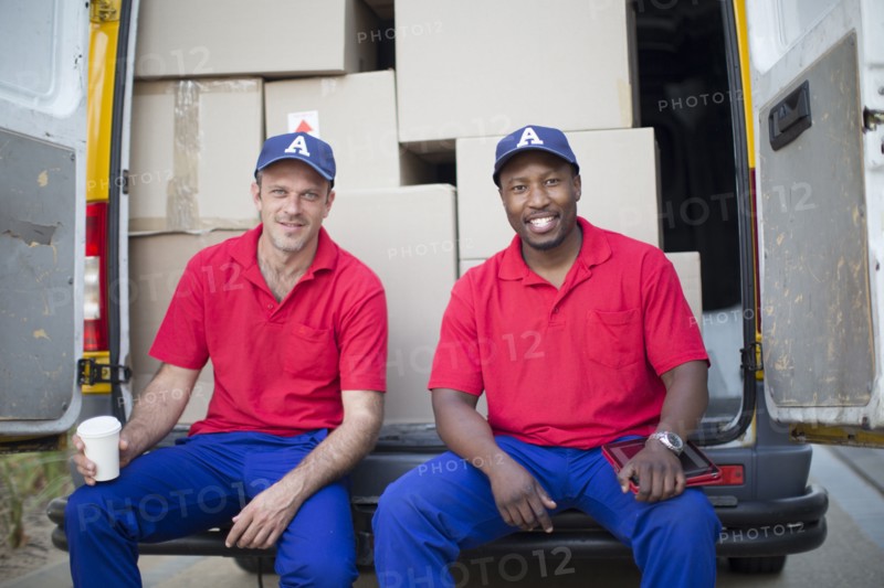 Delivery men sitting with packages in van