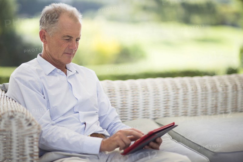 Caucasian man using digital tablet on sofa outdoors
