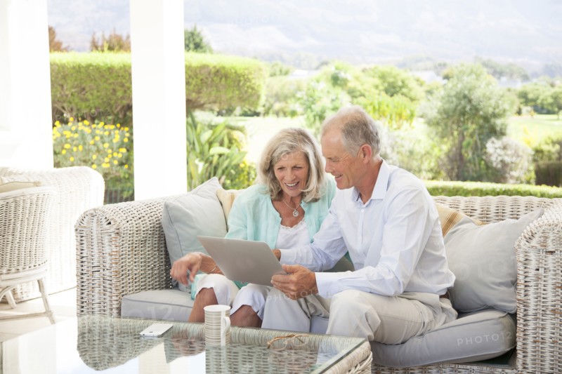 Caucasian couple using digital tablet on sofa outdoors