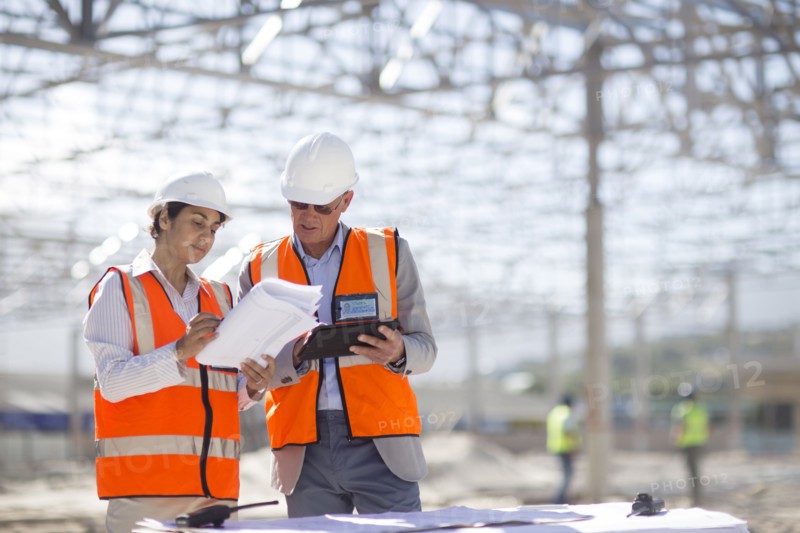 Architects reading blueprints at construction site