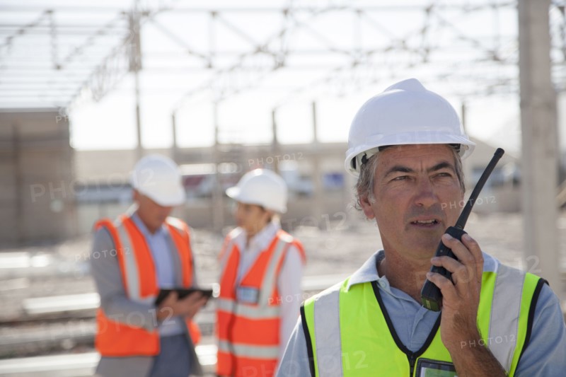 Worker talking on walkie-talkie at construction site