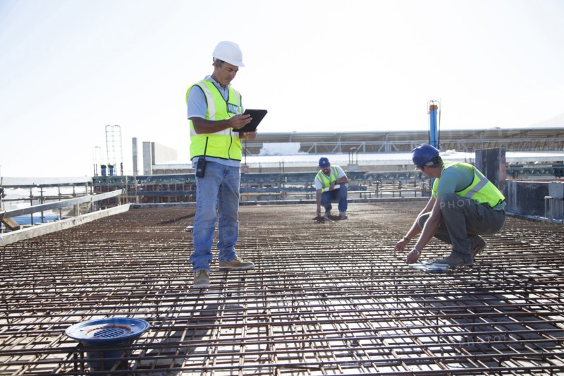 Construction workers arranging rebar at construction site