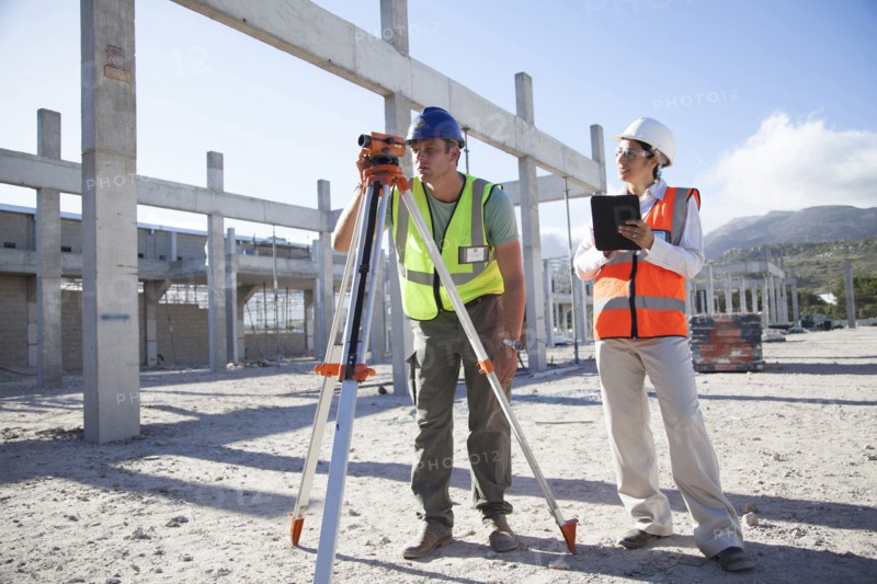 Surveyor and architect working at construction site
