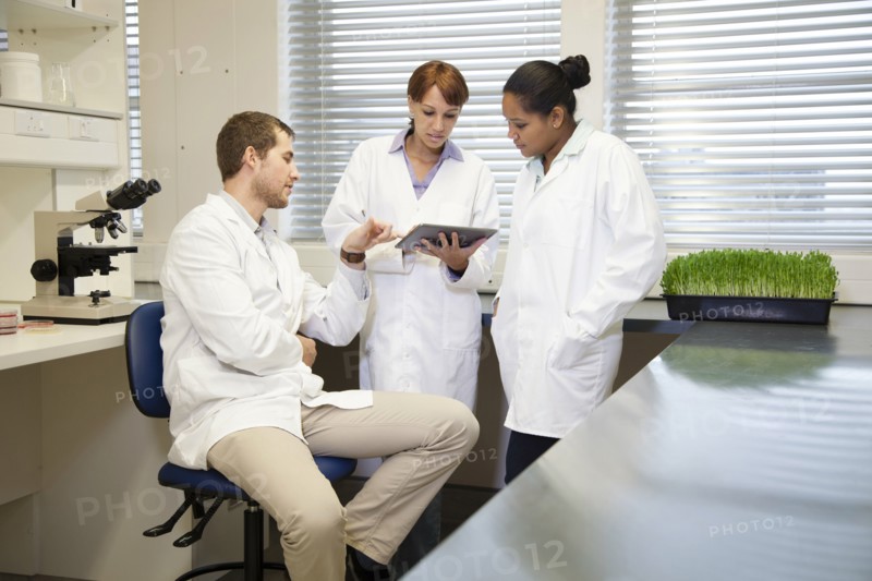 Scientists using digital tablet in laboratory