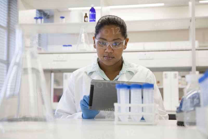 Mixed race scientist using digital tablet in laboratory