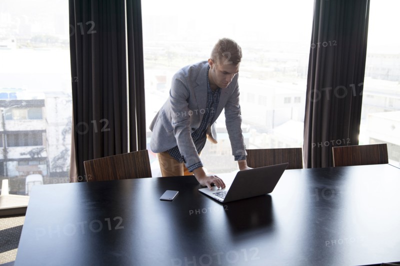 Caucasian businessman using laptop in conference room