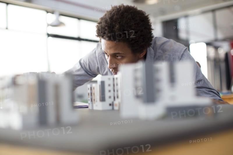 Mixed race architect examining architectural model in office