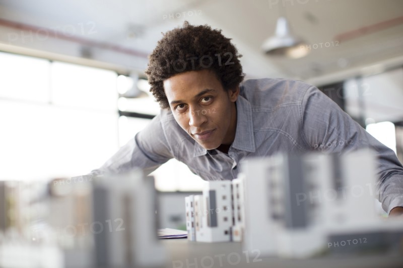 Mixed race architect examining architectural model in office
