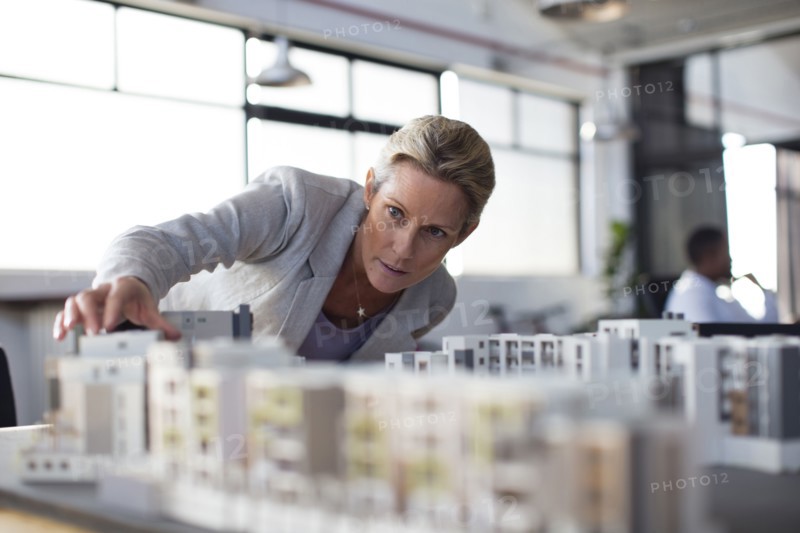 Caucasian architect examining architectural model in office