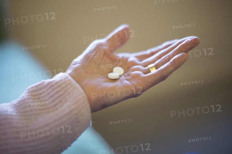Older Caucasian woman holding medication