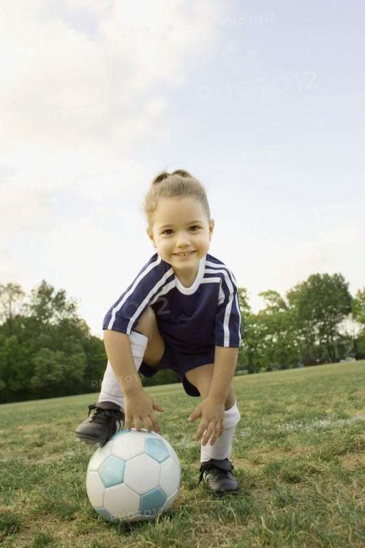 Young girl in athletic gear with soccer ball