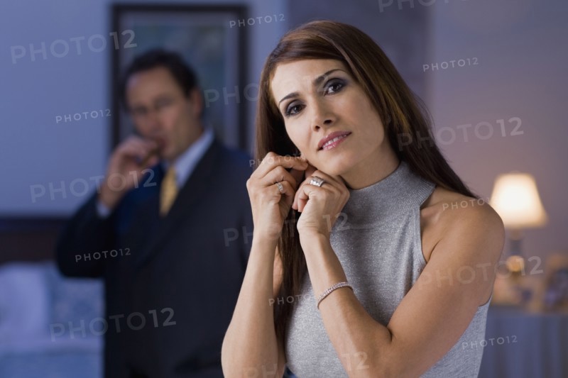 Hispanic woman fastening earring